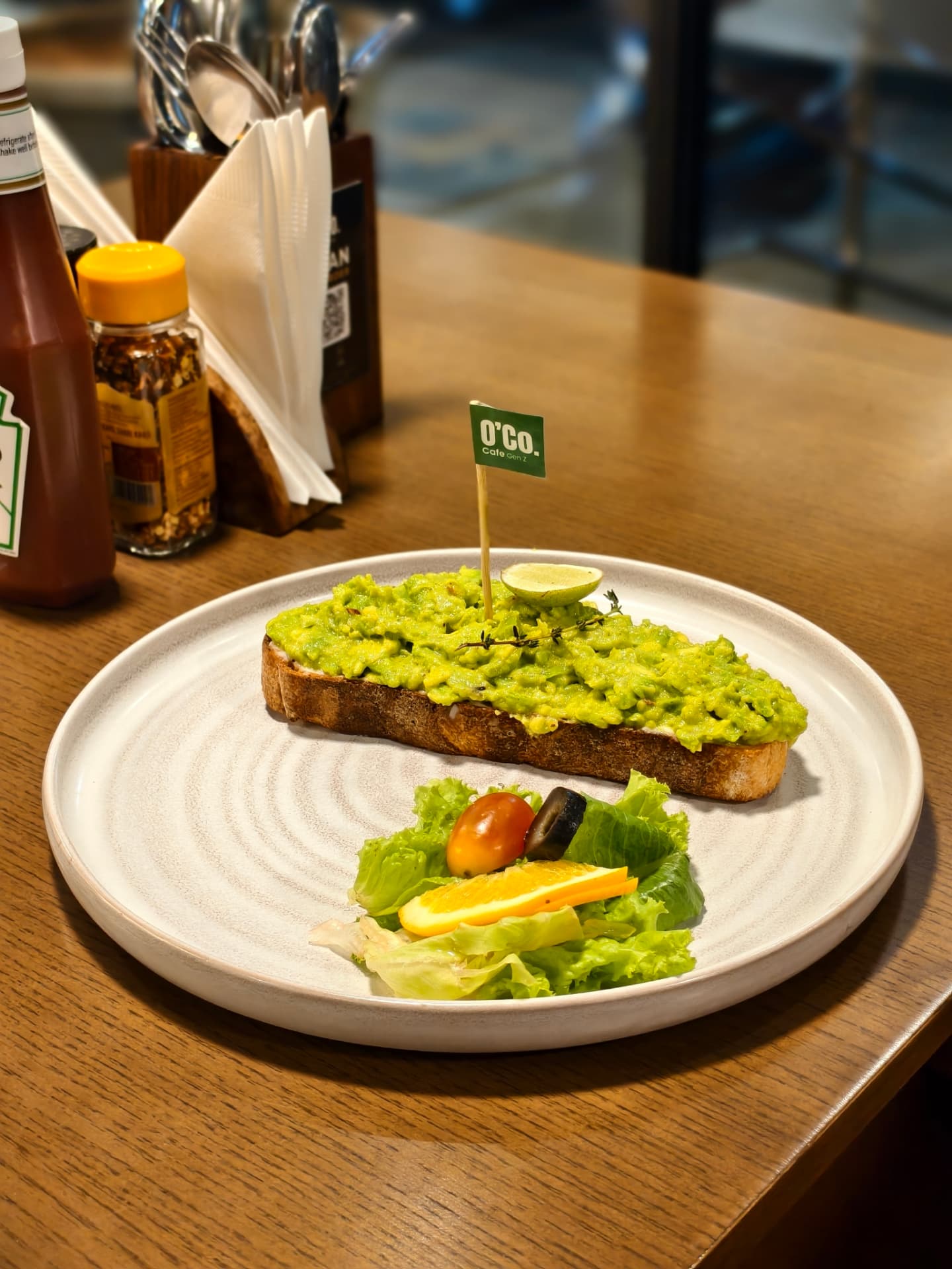 Avocado toast with an O’Co flag pick and a small salad